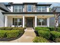 Inviting front porch with stone pillars, seating, and manicured hedges at 236 Lakestone Pkwy, Woodstock, GA 30188