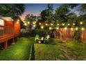 Fenced backyard with string lights, a fire pit and green lawn, great for outdoor gatherings at 1518 Langston Sw Ave, Atlanta, GA 30310