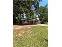Quaint single story home with a green metal roof and a cozy front yard at 10591 Flat Shoals Rd Rd, Covington, GA 30016