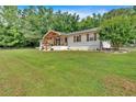 Well-kept front yard leading to a lovely home with an inviting front porch and surrounding green spaces at 146 Henderson Farm Ln, Canton, GA 30115