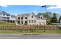 Elegant two-story home with a well-manicured lawn, wrought iron fence and neutral-toned brick exterior at 3785 Lower Roswell Rd, Marietta, GA 30068