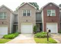 Townhome with brick and siding, featuring a garage and landscaped front yard at 5590 Stonewood Court Ct, Norcross, GA 30093