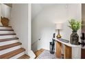 Entryway with wooden staircase, console table, modern lamp and verdant decor at 904 Ivy Green Se Ln, Marietta, GA 30067