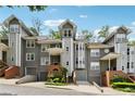 Exterior shot of townhomes with gray siding, brick accents, and individual garages under a blue sky at 904 Ivy Green Se Ln, Marietta, GA 30067