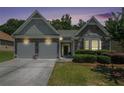 Beautiful home exterior featuring a stone facade, two-car garage, and manicured lawn at 1856 Temple Park Dr, Loganville, GA 30052
