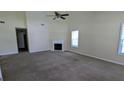 Bright living room featuring neutral walls, carpeting, and a cozy fireplace at 6572 Chestnut Oaks Rdg, Lithonia, GA 30038