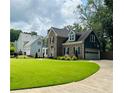 Traditional two-story brick home with an attached garage and meticulously maintained lawn at 735 Jamie Ne Way, Woodstock, GA 30188