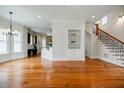 Open-concept living room featuring hardwood floors, built-in shelves, and staircase at 1505 Walker Ave, College Park, GA 30337
