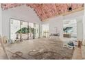 Living room with vaulted ceilings featuring bright sunlight and large windows showing the surrounding backyard at 141 N. Trace, Alpharetta, GA 30009