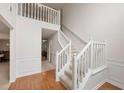 Entryway featuring hardwood floors, high ceilings, staircase with white railing and wainscotting at 2210 Benidorm Ct, South Fulton, GA 30349