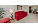 Cozy living room with bright red sofa, glass tables, and a view of the dining room at 2210 Benidorm Ct, South Fulton, GA 30349