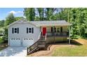 Charming two-story home with a front porch and a bright red front door at 276 Indian Creek Dr, Powder Springs, GA 30127