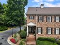 Exterior of a well-maintained two-story red brick house with a lush green lawn and landscaping at 2584 Oglethorpe Ne Cir, Brookhaven, GA 30319