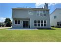 Back exterior view showcasing sliding glass door with a large grass area at 8965 Friarbridge Dr, Suwanee, GA 30024