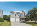 Attractive two-story home with a stone facade, a two-car garage, and mature trees at 8965 Friarbridge Dr, Suwanee, GA 30024
