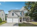 Charming two-story home with stone details, a two-car garage, and lush landscaping at 8965 Friarbridge Dr, Suwanee, GA 30024