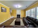 Inviting living room features a fireplace, plush seating, and wood-look flooring at 8965 Friarbridge Dr, Suwanee, GA 30024