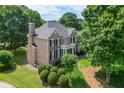 Charming two-story brick home with lush landscaping, offering a serene and inviting curb appeal at 1024 Cromwell Pt, Snellville, GA 30078