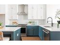 Charming kitchen features white and blue cabinets, stainless steel appliances, and modern backsplash at 7220 Summit Pl, Alpharetta, GA 30009