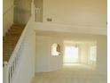 Spacious living room with a view of the staircase, chandelier, and large window, offering a bright and airy space at 4232 Kensington Cv, Atlanta, GA 30349