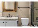 Bathroom with granite counters, framed mirror, and tiled walk-in shower at 55 Moray Pl, Covington, GA 30014