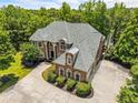 Elegant brick home on a vast lot with a lake view, showcasing meticulous landscaping and architectural detail at 55 Moray Pl, Covington, GA 30014
