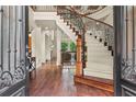 Grand foyer boasting a curved staircase with iron railings and hardwood floors, showcasing an open layout at 55 Moray Pl, Covington, GA 30014