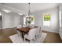 Elegant dining room with hardwood floors, a stylish chandelier, and ample natural light at 6320 Halcyon Garden Dr, Alpharetta, GA 30005