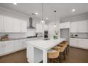 Modern kitchen featuring white cabinets, a large center island with seating, and stainless steel appliances at 6320 Halcyon Garden Dr, Alpharetta, GA 30005