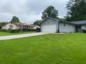 Quaint single story home on large lot with a sprawling green lawn and an extended concrete driveway at 284 Regal Dr, Lawrenceville, GA 30046