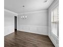 Elegant dining room featuring paneled walls, wood floors, and a chandelier, perfect for entertaining guests at 3717 Blue Goose Ln, Loganville, GA 30052