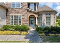 Charming front entrance with a light blue door, stone accents, and beautiful landscaping at 3952 Dragon Fly Ln, Loganville, GA 30052