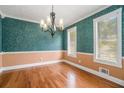 Elegant dining room featuring chair rail, decorative wallpaper, and hardwood floors at 1105 Tom Lane Ln, Marietta, GA 30066