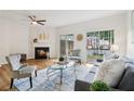 Inviting living room with fireplace, hardwood floors, ceiling fan, and sliding glass doors to outdoor area at 528 Lantern Wood Dr, Scottdale, GA 30079