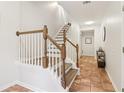 Hallway featuring a staircase with wooden handrail and trim with tile flooring at 528 Lantern Wood Dr, Scottdale, GA 30079