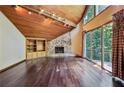 Bright living room with stone fireplace, wood ceiling, hardwood floors, and large windows at 562 Pine Valley Se Rd, Marietta, GA 30067