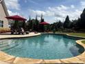 Inviting backyard pool area with stone surround and lounge seating at 848 Rolling Nw Hl, Kennesaw, GA 30152