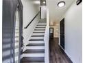 Entryway showcasing staircase with black handrail and modern flooring at 131 Turning Point, Stockbridge, GA 30281