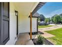 Covered porch with wood support columns, manicured flower bed, and view of the street at 131 Turning Point, Stockbridge, GA 30281