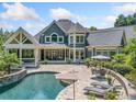Inviting backyard featuring a sparkling pool, patio with lounge furniture, and a covered porch for outdoor entertaining at 3090 Creek Tree Lane, Cumming, GA 30041