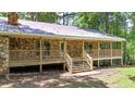 Charming one story stone-clad home featuring a wooden porch and front door, set in a forested lot at 257 Martin Ln, Canton, GA 30114