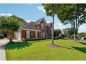 Beautiful brick home featuring a lush green lawn and mature trees at 7160 Fawn Lake Dr, Alpharetta, GA 30005