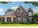 Charming two-story brick home with manicured lawn and mature landscaping at 7160 Fawn Lake Dr, Alpharetta, GA 30005