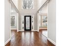 Elegant foyer featuring hardwood floors, wainscoting, decorative door, and views to the living area at 7160 Fawn Lake Dr, Alpharetta, GA 30005