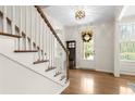 Bright foyer features hardwood floors, staircase, and view of entry with sidelights at 1215 Renaissance Se Ct, Mableton, GA 30126
