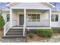A welcoming front porch with gray stairs, white railings, and a stylish gray front door at 1631 Dresden Ne Dr, Brookhaven, GA 30319