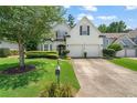 Beautiful home featuring a lush green lawn, mature trees, and a well-maintained driveway leading to the garage at 217 Springs Xing, Canton, GA 30114