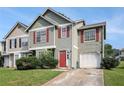 Inviting two-story townhouse featuring red shutters, a red door, and a one-car garage at 3835 Conley Downs Dr, Decatur, GA 30034