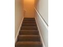 Carpeted staircase featuring white railings, providing access to the upper level of the home at 8170 Oakley Cir, Union City, GA 30291