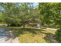 Brick home with a beautifully landscaped front yard and mature trees at 4989 Woodfall Sw Dr, Lilburn, GA 30047